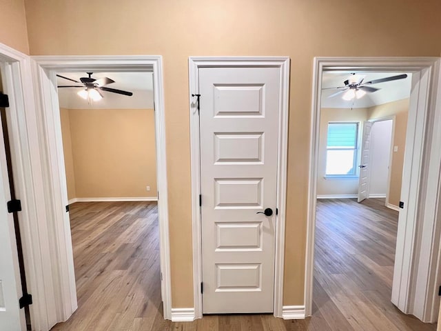 hallway featuring wood finished floors and baseboards