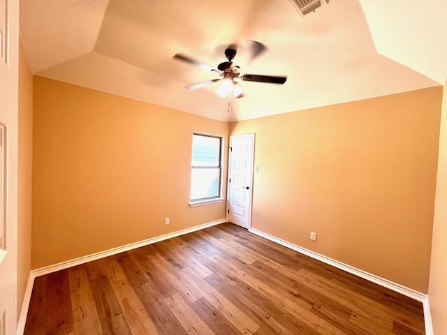 unfurnished room featuring visible vents, wood finished floors, baseboards, and ceiling fan