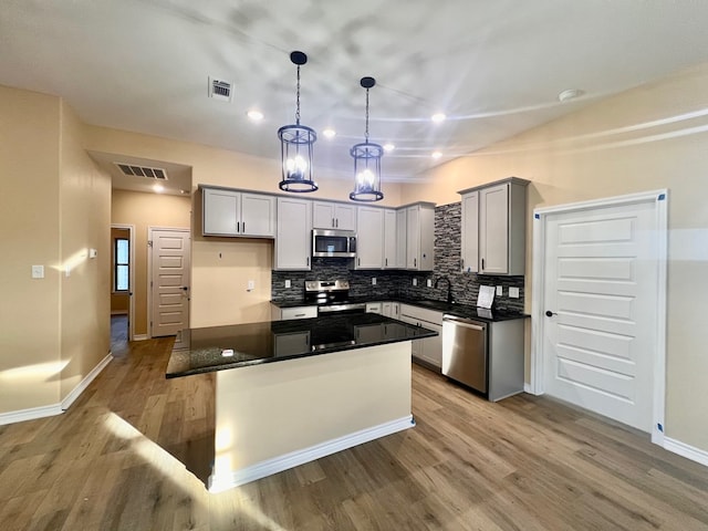 kitchen featuring dark countertops, visible vents, appliances with stainless steel finishes, and a sink