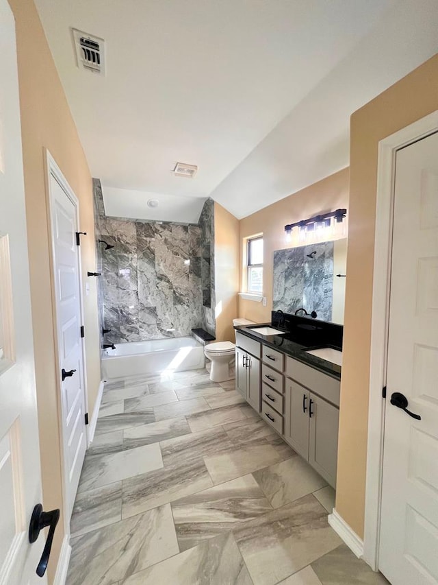 full bathroom featuring visible vents, toilet, lofted ceiling, double vanity, and a sink