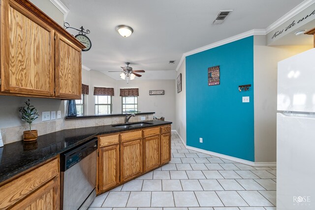 kitchen featuring light tile patterned flooring, sink, dark stone countertops, white fridge, and stainless steel dishwasher