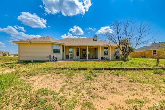 rear view of house with a lawn and a patio