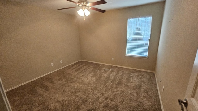 carpeted spare room featuring ceiling fan