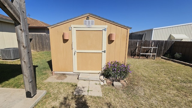 view of outdoor structure with a lawn and central air condition unit