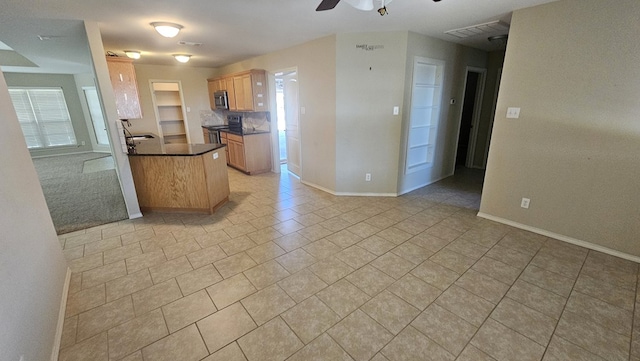 kitchen featuring black / electric stove, light tile patterned flooring, ceiling fan, and light brown cabinets