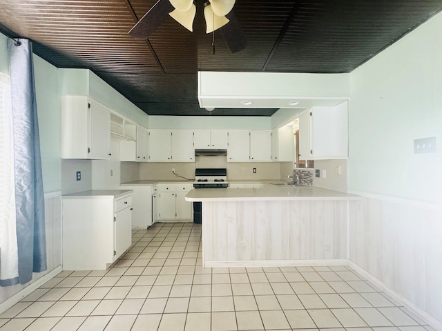 kitchen with sink, ceiling fan, white cabinets, kitchen peninsula, and white gas stove