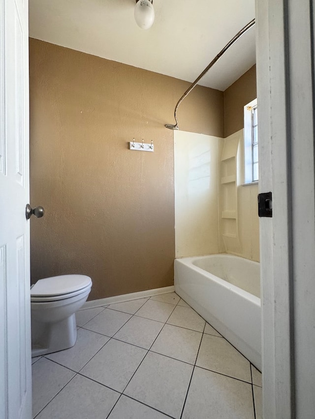 bathroom featuring tile patterned flooring, bathtub / shower combination, and toilet