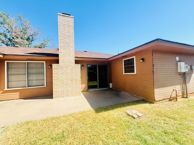 back of property with a yard and a patio area