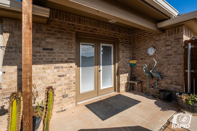 property entrance featuring a patio area and french doors