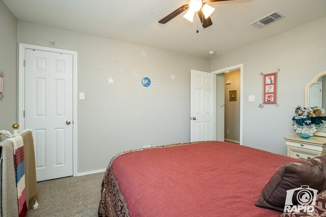 carpeted bedroom featuring a ceiling fan, visible vents, and baseboards