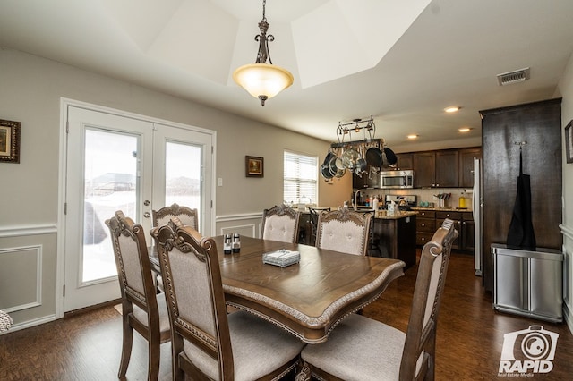 dining room with dark hardwood / wood-style floors and french doors