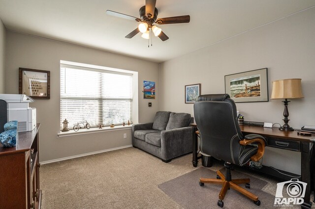 carpeted home office featuring ceiling fan