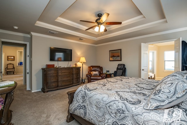 bedroom with a tray ceiling, carpet flooring, visible vents, and crown molding