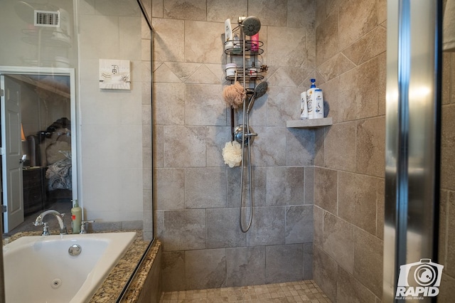 bathroom featuring tiled shower, a jetted tub, and visible vents