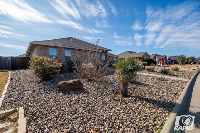 view of home's exterior with brick siding and fence