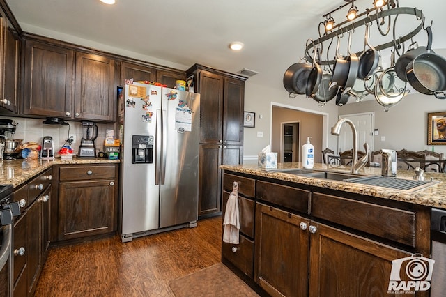 kitchen with dark brown cabinets, tasteful backsplash, light stone countertops, dark hardwood / wood-style flooring, and stainless steel fridge with ice dispenser