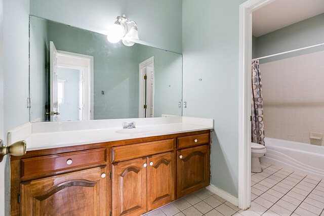 bathroom with vanity, baseboards, tile patterned flooring, shower / bath combination with curtain, and toilet