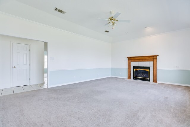 unfurnished living room featuring carpet, visible vents, ceiling fan, tile patterned flooring, and a tile fireplace