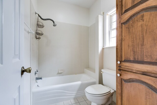 bathroom with tub / shower combination, toilet, and tile patterned flooring