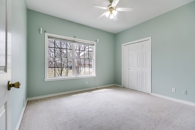 unfurnished bedroom with a closet, ceiling fan, baseboards, and carpet floors