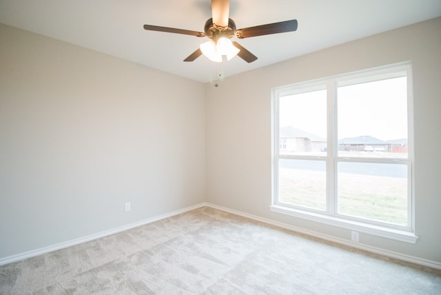 unfurnished room featuring ceiling fan, light colored carpet, and a healthy amount of sunlight