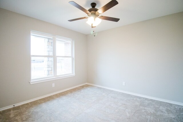 carpeted spare room featuring ceiling fan