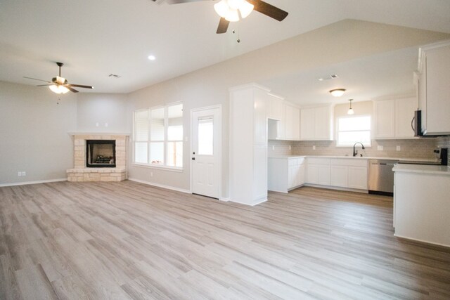 kitchen with backsplash, stainless steel appliances, light hardwood / wood-style floors, and white cabinets