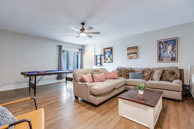 living room with french doors, light wood finished floors, a ceiling fan, and baseboards