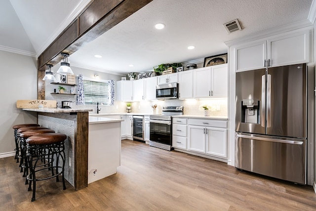 kitchen with stainless steel appliances, wine cooler, wood finished floors, and visible vents