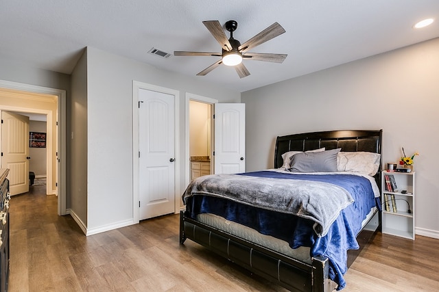 bedroom featuring baseboards, visible vents, ceiling fan, and wood finished floors