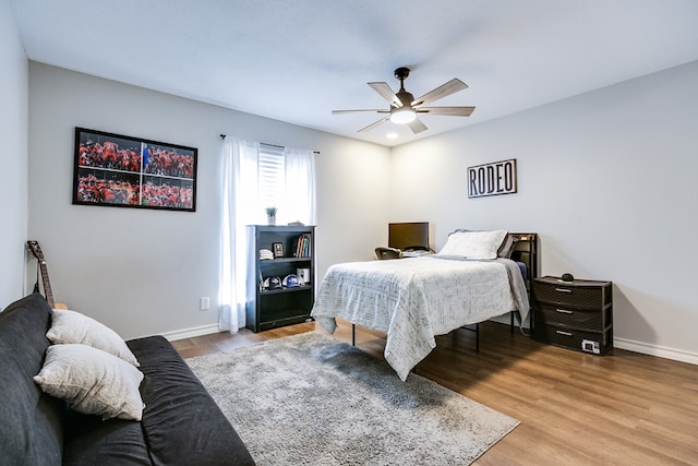 bedroom with ceiling fan, baseboards, and wood finished floors