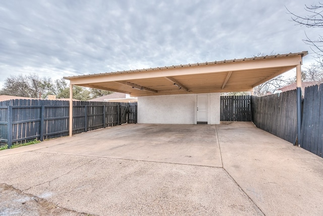 view of patio / terrace featuring a carport, fence, and driveway