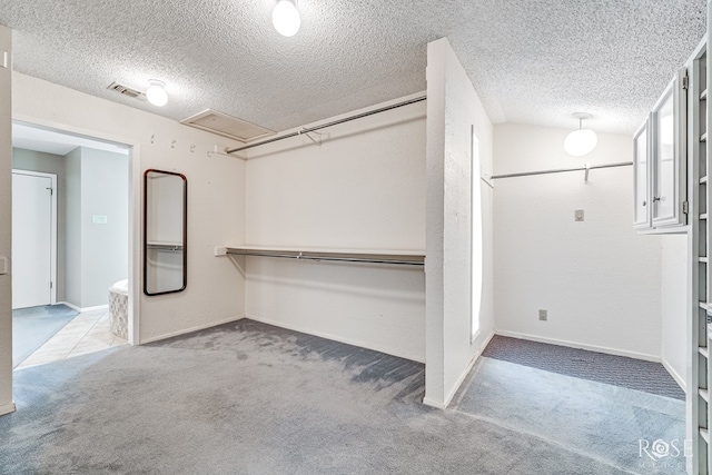 walk in closet featuring light colored carpet