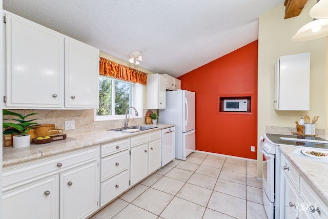 kitchen featuring light tile patterned flooring, white cabinetry, sink, white appliances, and a textured ceiling