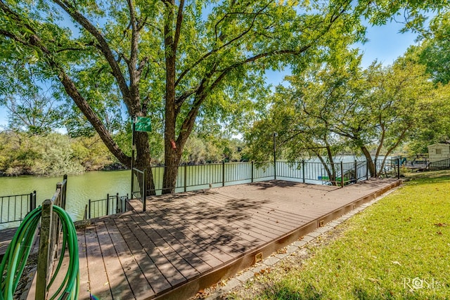 deck with a water view, a yard, and a boat dock