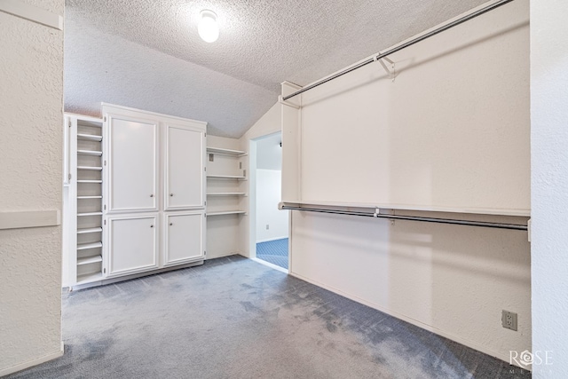 walk in closet featuring vaulted ceiling and light colored carpet