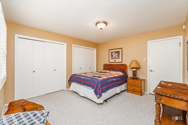 bedroom featuring carpet and two closets