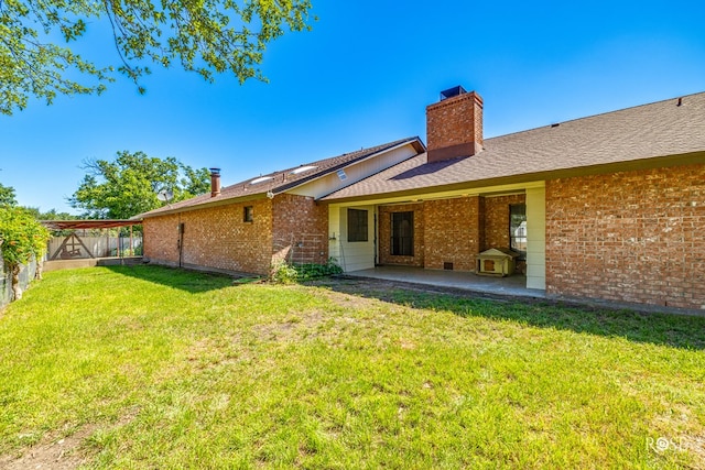 back of property with a yard and a patio