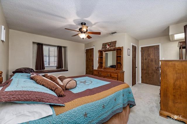 bedroom featuring light colored carpet, a textured ceiling, and ceiling fan