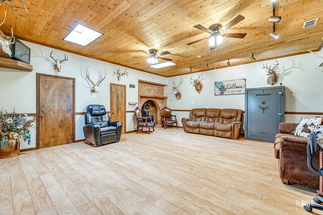 living room featuring light hardwood / wood-style flooring, wooden ceiling, ceiling fan, and a skylight