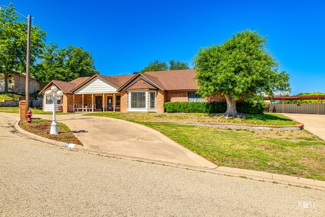 single story home featuring a porch and a front yard