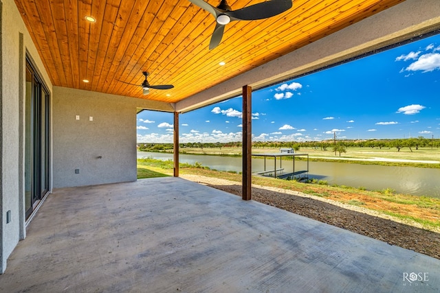 view of patio featuring a water view and ceiling fan