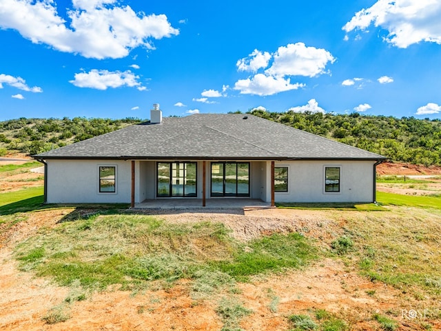 rear view of property featuring a patio and a yard