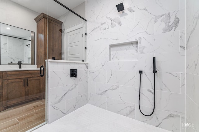 bathroom with vanity and a tile shower