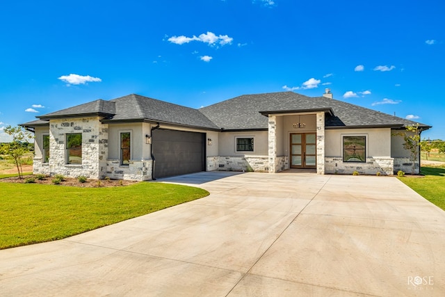 prairie-style home with a garage and a front lawn