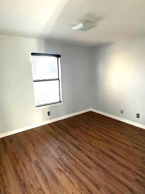 spare room with dark wood-type flooring