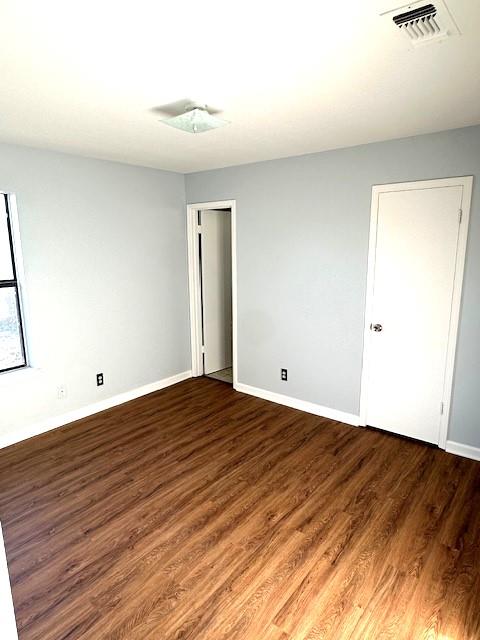 spare room featuring dark wood-type flooring