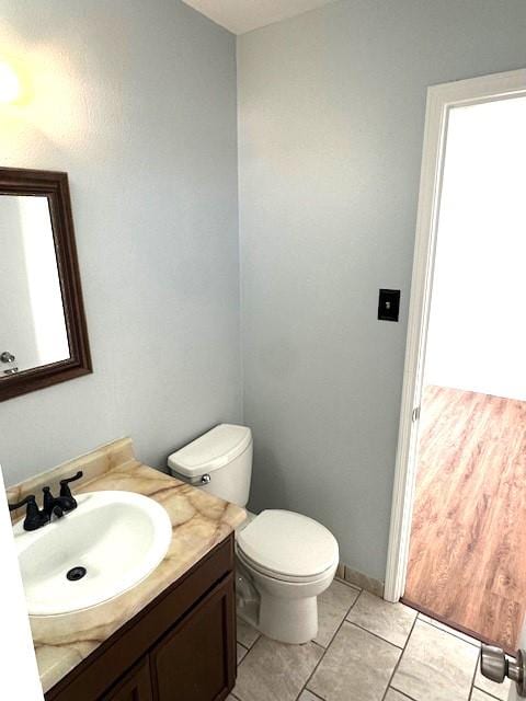 bathroom featuring vanity, tile patterned flooring, and toilet