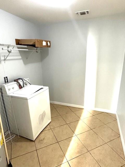 laundry area with light tile patterned floors and washer / dryer