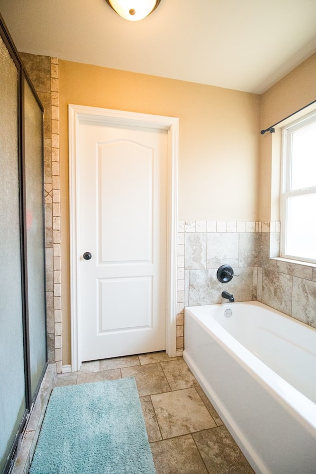 full bath featuring a bath and a shower stall